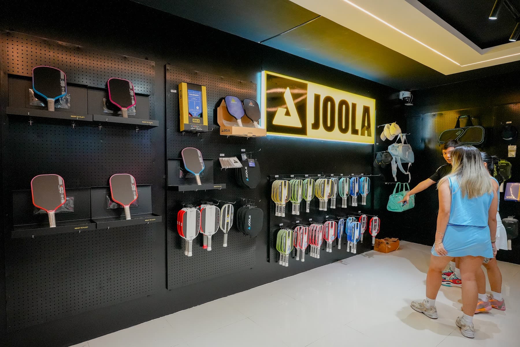 Players exploring pickleball equipment in Tela's publicly shared facility gallery